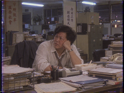Wai-keung, tired and alone at his office desk after hours